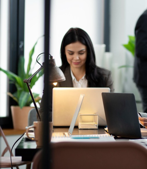 Junge Frau arbeitet konzentriert an einem Laptop im modernen Büro – berufliche Entwicklung bei Rechtsschutzengel.